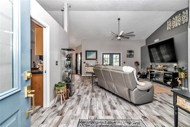 living room featuring lofted ceiling, french doors, and ceiling fan