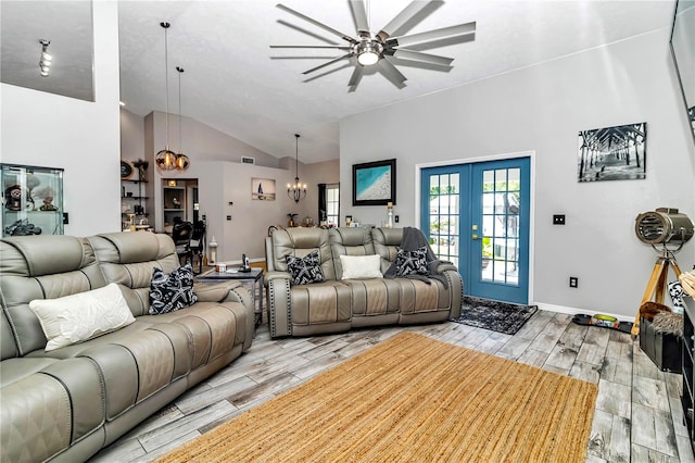 living room featuring ceiling fan with notable chandelier, high vaulted ceiling, and french doors