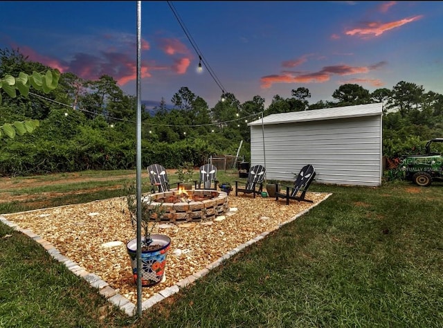 yard at dusk featuring a fire pit