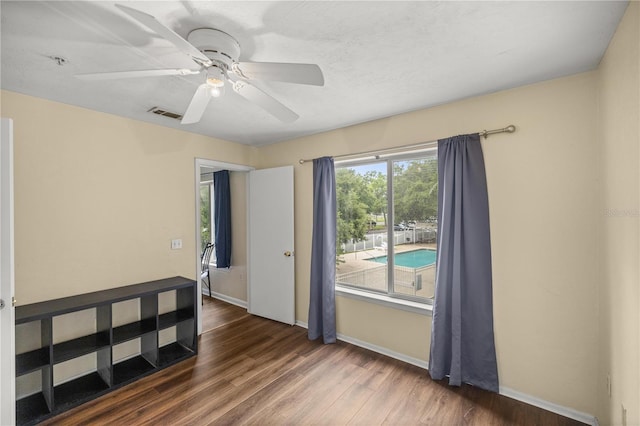 unfurnished room with dark hardwood / wood-style floors and ceiling fan