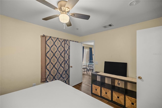 bedroom with dark hardwood / wood-style flooring and ceiling fan