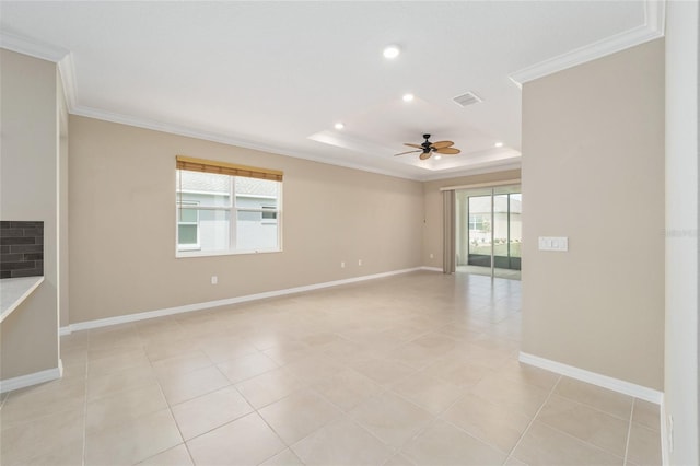 empty room with a raised ceiling, ceiling fan, crown molding, and light tile patterned flooring