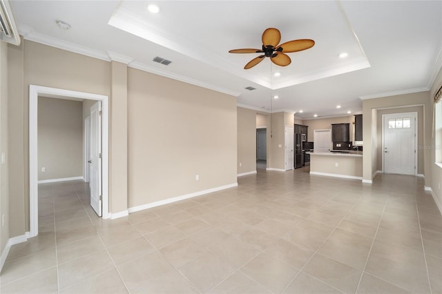 unfurnished living room with light tile patterned floors, a raised ceiling, ceiling fan, and ornamental molding