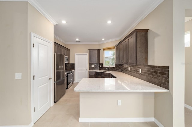 kitchen with kitchen peninsula, appliances with stainless steel finishes, light stone countertops, dark brown cabinetry, and light tile patterned flooring