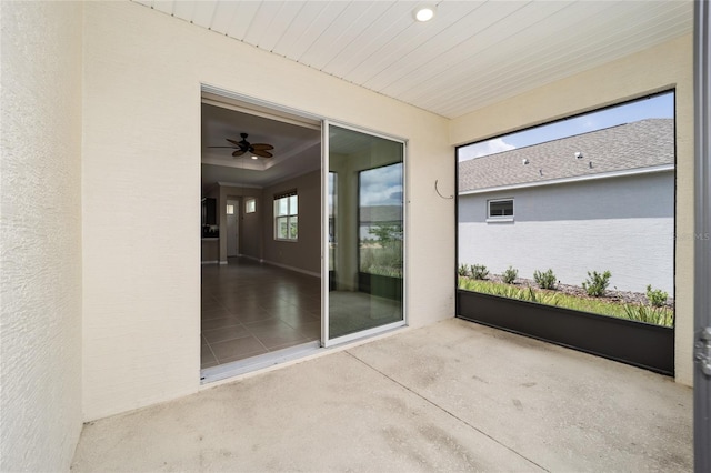 unfurnished sunroom featuring ceiling fan