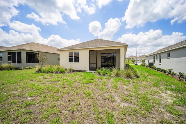 rear view of property featuring a lawn