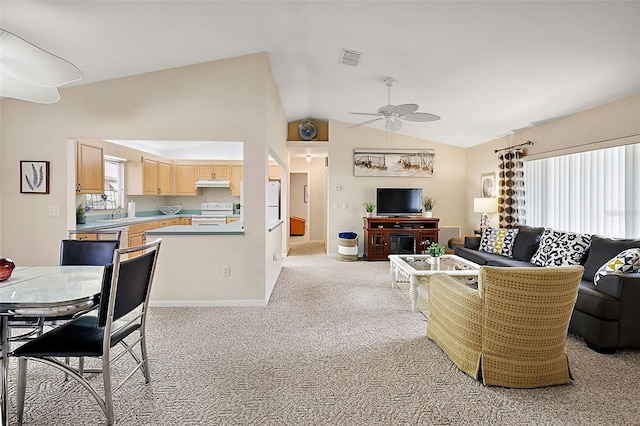 living room with light carpet, vaulted ceiling, plenty of natural light, and ceiling fan