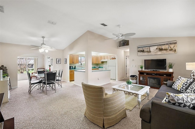 living room featuring light colored carpet, ceiling fan, and lofted ceiling