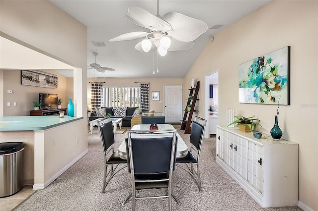 dining space with light colored carpet, vaulted ceiling, and ceiling fan