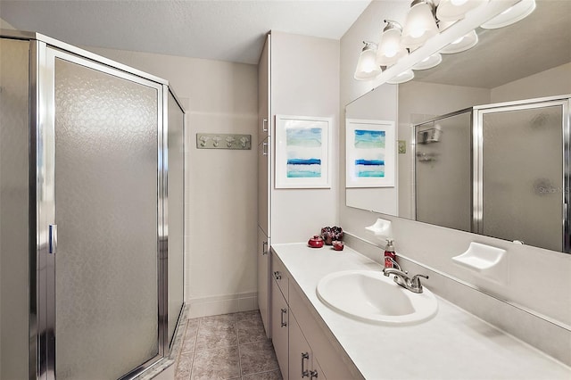 bathroom with tile patterned flooring, vanity, a textured ceiling, and walk in shower