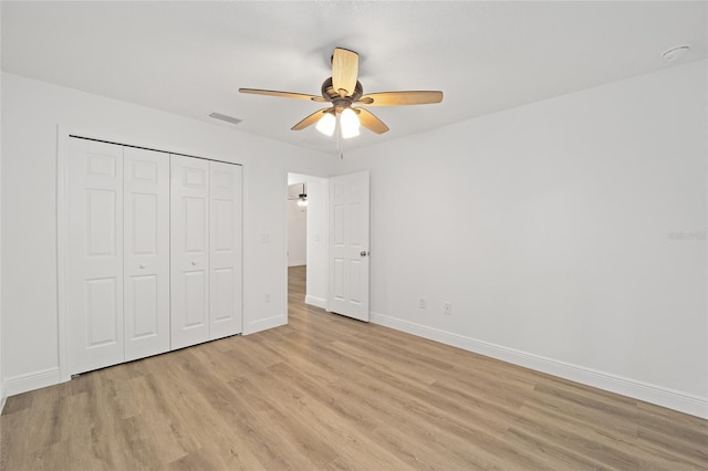 unfurnished bedroom featuring ceiling fan, a closet, and light hardwood / wood-style floors