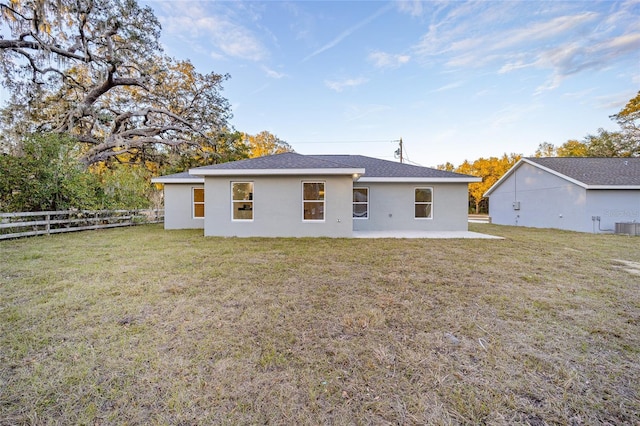 rear view of property featuring central AC, a lawn, and a patio