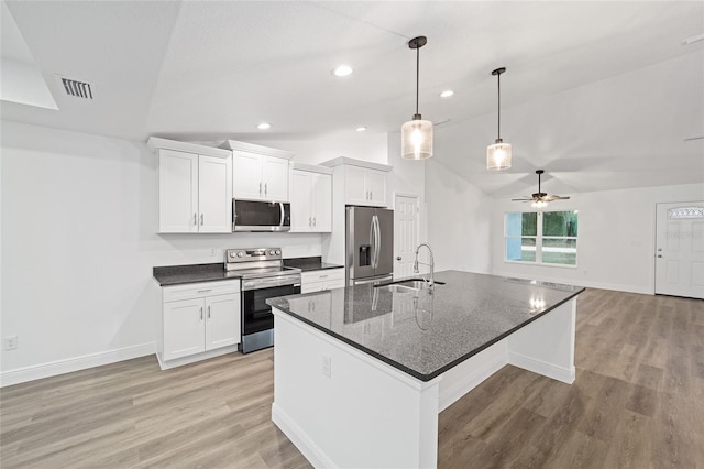 kitchen featuring lofted ceiling, white cabinets, and appliances with stainless steel finishes