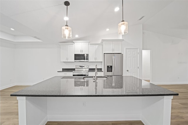 kitchen featuring appliances with stainless steel finishes, dark stone countertops, and white cabinetry