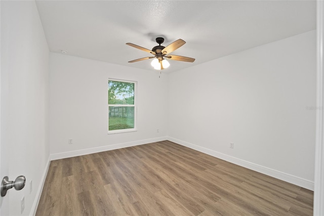 empty room with ceiling fan and hardwood / wood-style floors