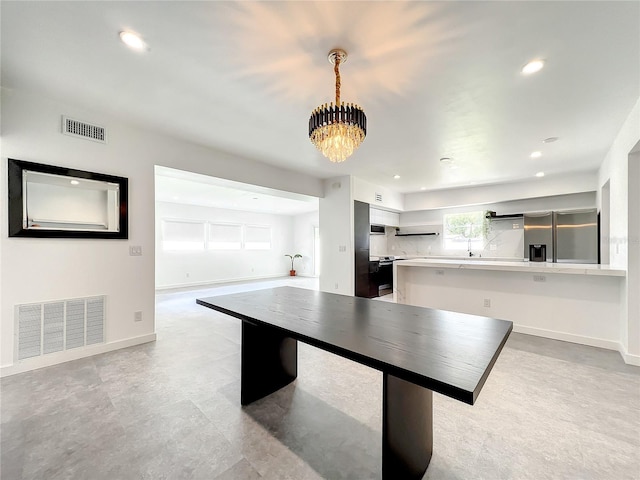 recreation room featuring baseboards, visible vents, and a notable chandelier