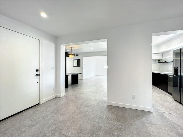 unfurnished living room featuring recessed lighting and baseboards