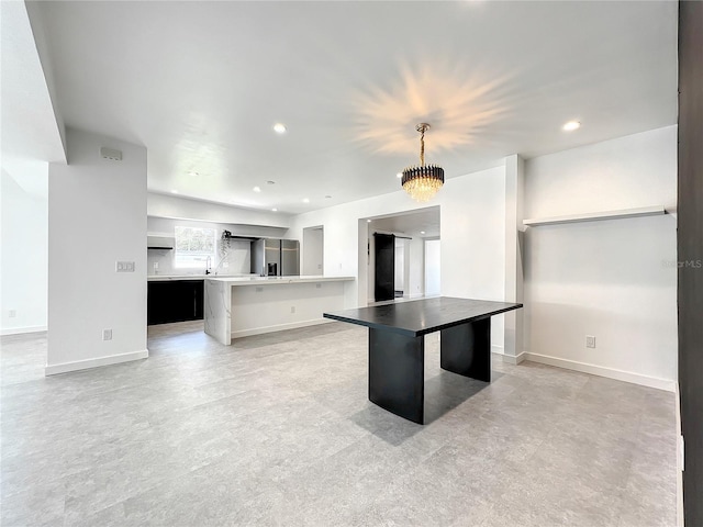 kitchen featuring recessed lighting, light countertops, hanging light fixtures, and baseboards