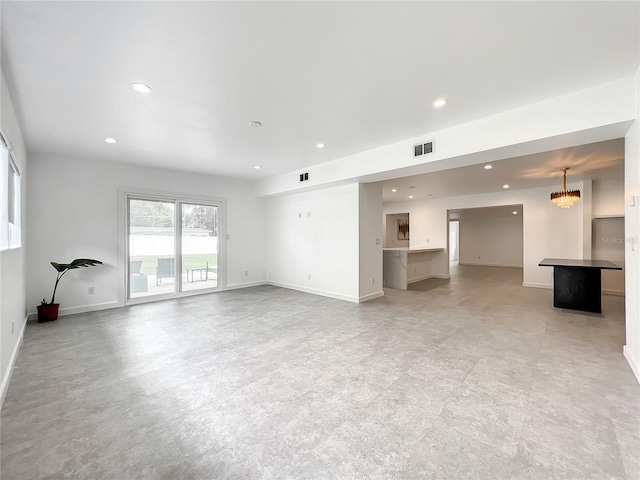 unfurnished living room with baseboards, visible vents, and recessed lighting