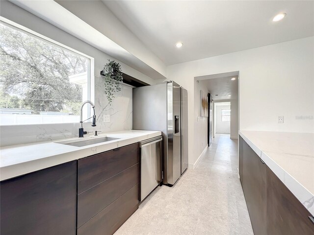 kitchen featuring light floors, appliances with stainless steel finishes, a sink, and recessed lighting