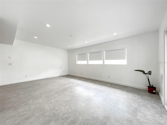 spare room featuring baseboards, concrete flooring, and recessed lighting