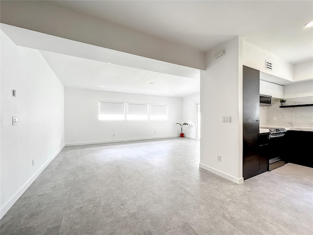 unfurnished living room featuring light floors, visible vents, and baseboards