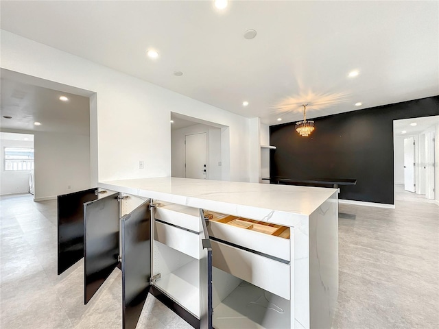 kitchen featuring recessed lighting, baseboards, and light stone countertops