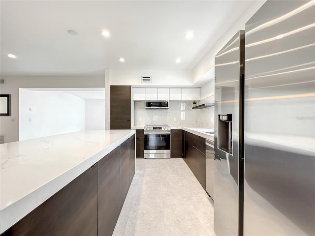 kitchen featuring visible vents, white cabinets, modern cabinets, appliances with stainless steel finishes, and dark brown cabinets