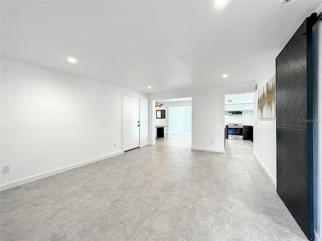 unfurnished living room with recessed lighting and baseboards