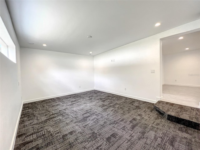 empty room featuring baseboards, dark colored carpet, and recessed lighting