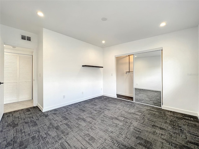 unfurnished bedroom with baseboards, visible vents, dark colored carpet, and recessed lighting