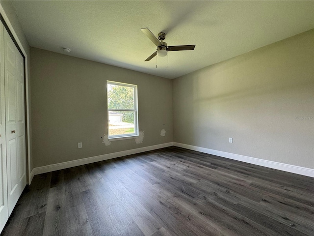 unfurnished bedroom featuring dark hardwood / wood-style floors, a closet, and ceiling fan