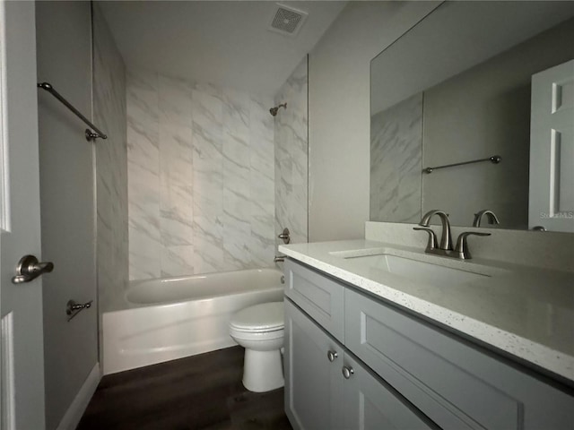 full bathroom featuring tiled shower / bath combo, vanity, hardwood / wood-style flooring, and toilet