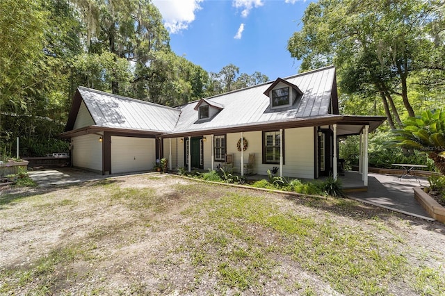 view of front of property featuring a front yard, a garage, and a porch