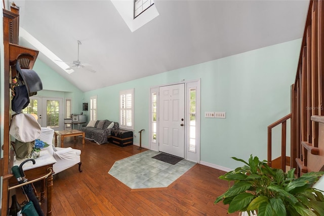 entrance foyer with ceiling fan, a skylight, dark wood-type flooring, and high vaulted ceiling