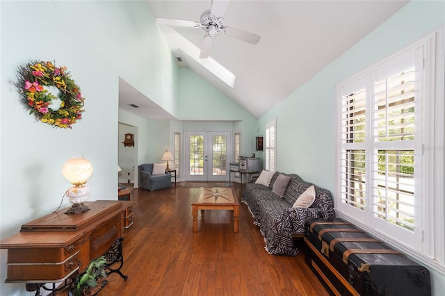 living room with a skylight, ceiling fan, dark hardwood / wood-style flooring, french doors, and high vaulted ceiling