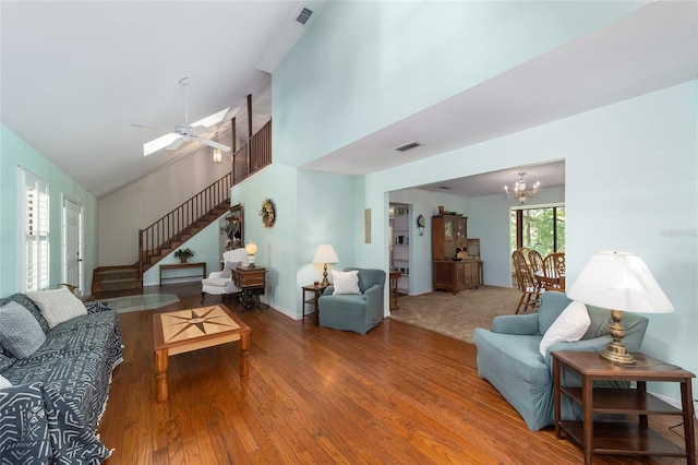 living room with ceiling fan with notable chandelier and wood-type flooring