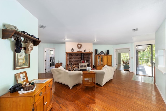 living room with a wood stove and hardwood / wood-style flooring