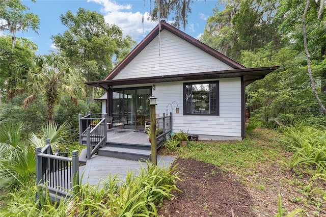 rear view of house featuring a deck and a sunroom