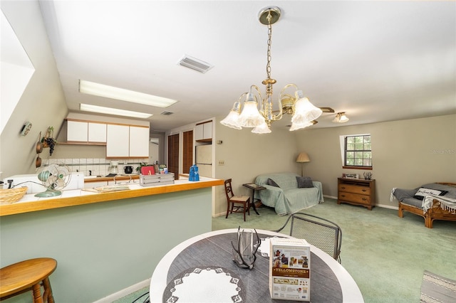 kitchen with pendant lighting, white cabinetry, light carpet, decorative backsplash, and kitchen peninsula