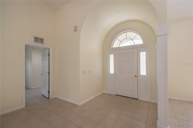 foyer entrance featuring a towering ceiling and light tile patterned floors