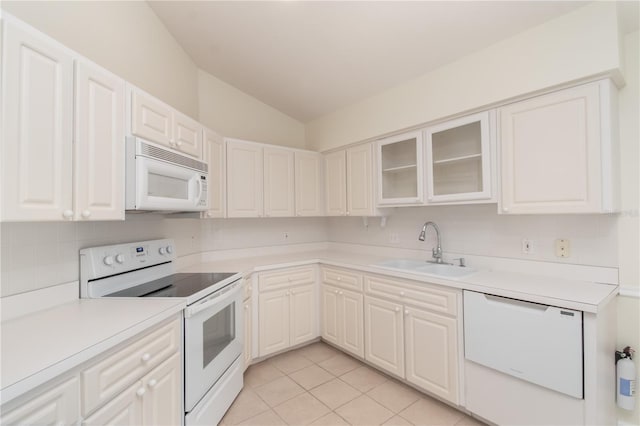 kitchen featuring light tile patterned flooring, white appliances, sink, vaulted ceiling, and backsplash