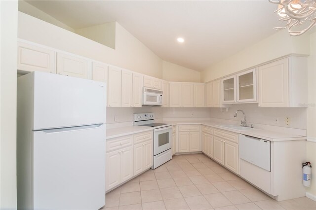 2260 NW 51st Ter, Ocala, FL 34482 - kitchen featuring white appliances, a sink, vaulted ceiling, light tile patterned floors, and light countertops
