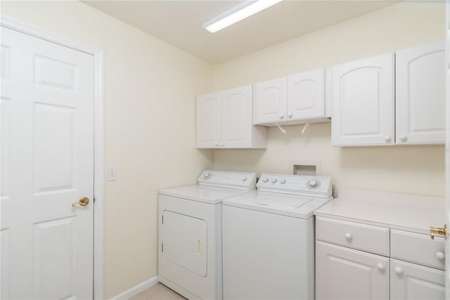 washroom with washer and clothes dryer and cabinets