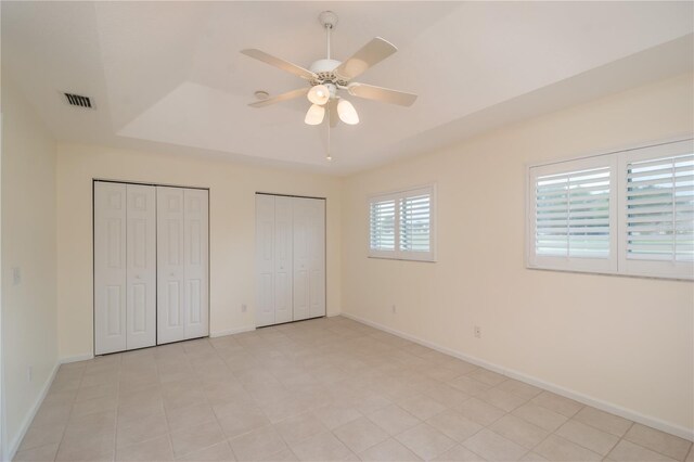 2260 NW 51st Ter, Ocala, FL 34482 - unfurnished bedroom featuring two closets, baseboards, and a raised ceiling