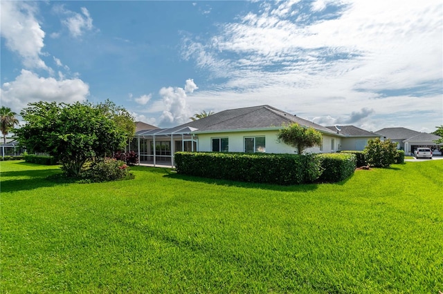 view of side of property with a lawn and a lanai