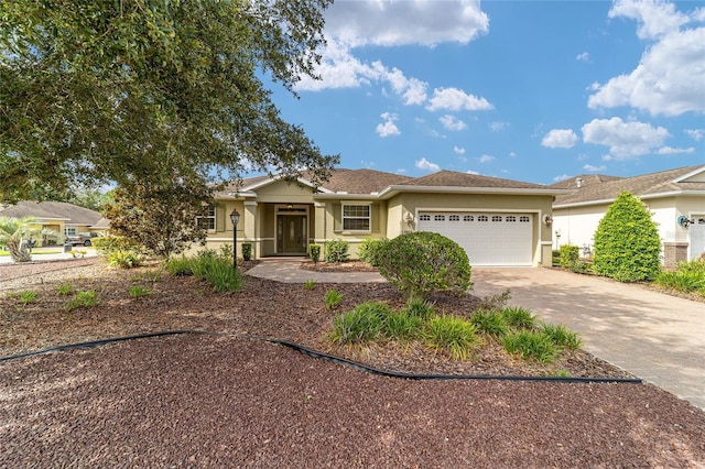 single story home with stucco siding, driveway, and a garage