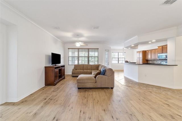 living room featuring crown molding, ceiling fan, and light hardwood / wood-style floors