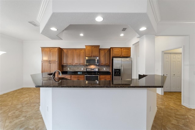 kitchen featuring ornamental molding, appliances with stainless steel finishes, a large island, and backsplash