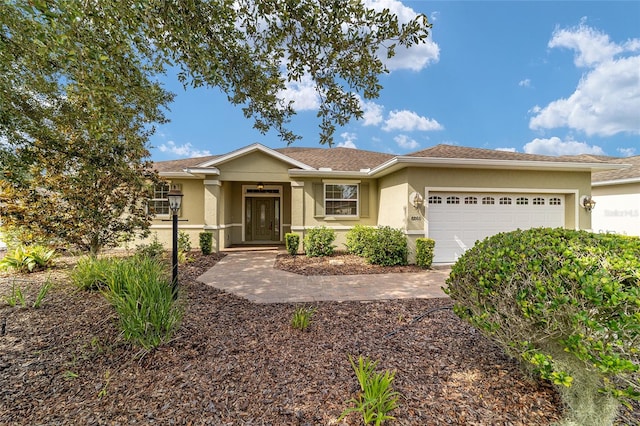 ranch-style home featuring stucco siding and a garage